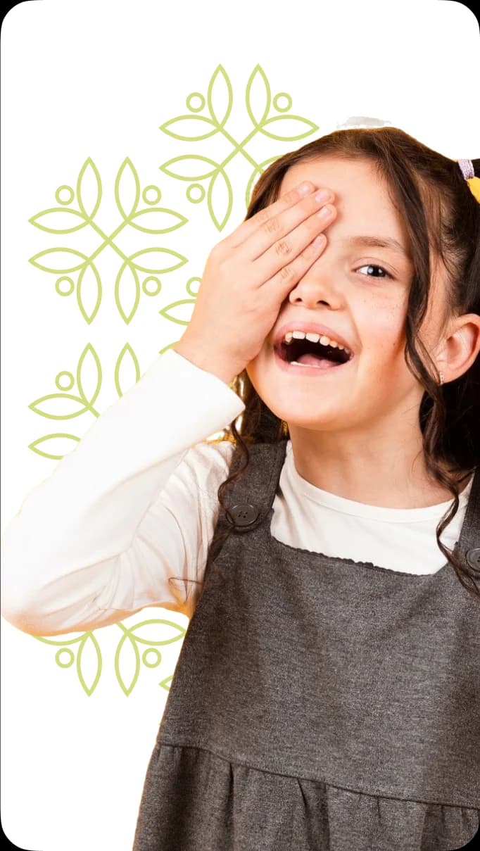 Girl hiding her eyes with hands, smiling.